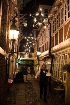 HAMBURG - DECEMBER 1, 2012: Beautiful and cozy old restaurant near St. Michel church on the evening of December 1, 2012 in Hamburg Germany. A waiter is carrying dishes from the small restaurant to the kitchen next door.