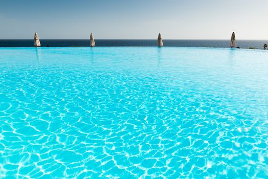 Empty blue infinity pool in crisp morning light