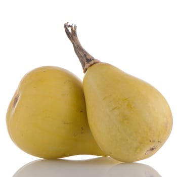 Closeup detail of yellow pumpkins on white reflective background.