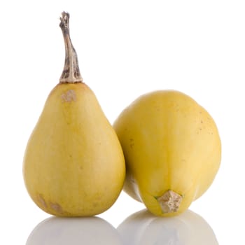 Closeup detail of yellow pumpkins on white reflective background.