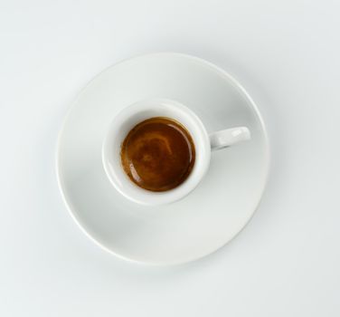 Cup of espresso viewed from above on white table