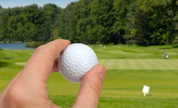 Hand Holding Golf Ball - Golf Green With Flag in Background