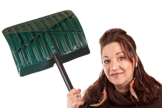 Brunette woman holding up her snow shovel isolated over a white backdrop.