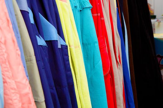 a lot of bright children's clothing on a hanger in the store