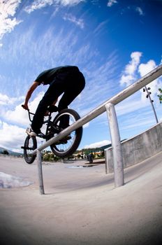 Biker doing double peg grind down the hand rail over the stairs