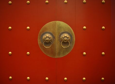Typical old Chinese red door with bronze dragon knocker