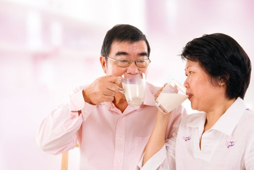 Southeast Asian mature couple drinking soy milk at home. 