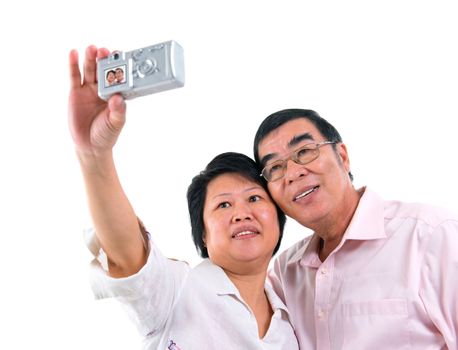 Southeast Asian senior couple self photographing, isolated on white