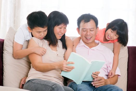 Southeast Asian family living lifestyle. Parents and children reading books at home.