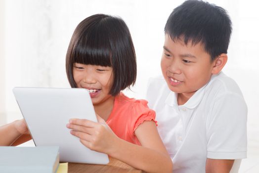 Southeast Asian family living lifestyle at home. Children using digital tablet computer together.