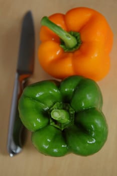 Two peppers and a knife on the kitchen table