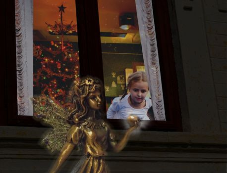 Little girl looking out of the window on Christmas Eve, seeing a glittering fairy holding a glowing apple.