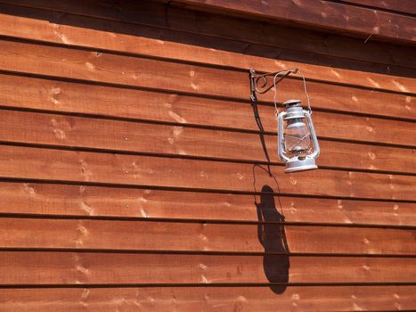 Classical oil lamp hanged on a wooden wall