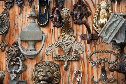 Collection of handmade metal door knockers on display in street flea market