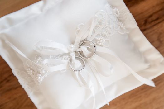 Silver wedding rings on a white pad