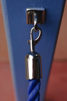 Vertical image of closed hook at the end of a blue rope
