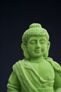 Green velver buddha against a black background