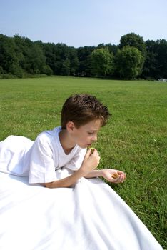 Boy eating olives in nature.