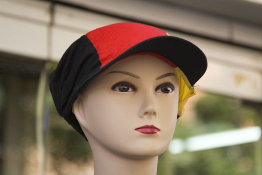 Close-up image of a mannequin of a young person with a hat 