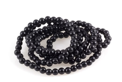 Necklace of black beads on a white background.