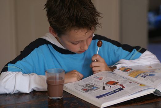 Young boy reading an encyclopedia.