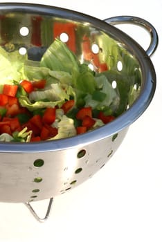 Isolated strainer with salad in it.                 