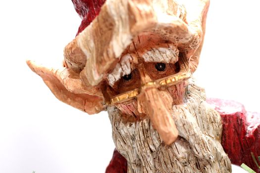 A wooden carving of Santa Claus elf on white background.