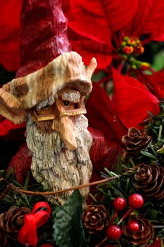 Wooden Statue of Santa Claus elf on poinsetta backdrop
