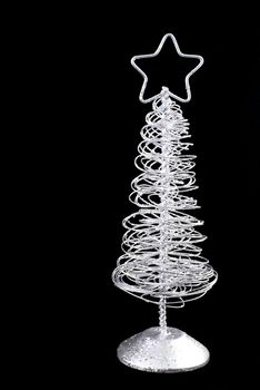 Abstract metal christmas tree isolated on black.