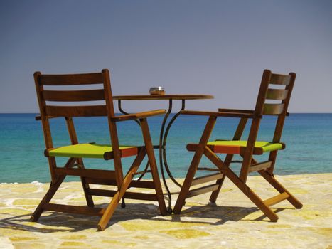 table with two chairs at the sea