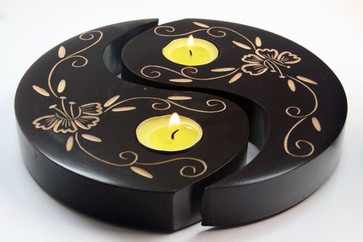 wooden ying yang with candes on fire