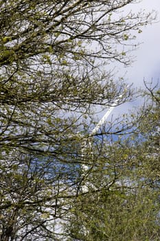 windmill on the hills of Glenough in county Tipperary Ireland seen through the tree branches