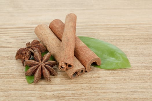 Star Anise, cinnamon and green leave isolated on wooden background 