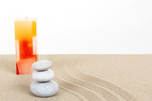Balance zen stones and candle in sand on white background