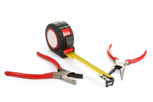 two different red pliers and measuring tape isolated on white