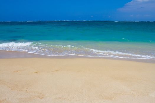 Beautiful tropical blue green water and a white sand beach on the north shore of Oahu in Hawaii. This image shows tropical paradise with a vacation getaway theme in a simple image.