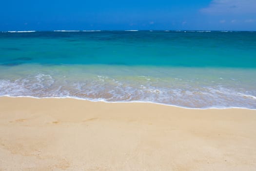 Beautiful tropical blue green water and a white sand beach on the north shore of Oahu in Hawaii. This image shows tropical paradise with a vacation getaway theme in a simple image.