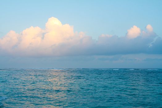 The yellow orange of the fading sunset light hits these clouds just right and reflects off the water on the north shore of Oahu in Hawaii. This nature landscape image is very simple yet unique.