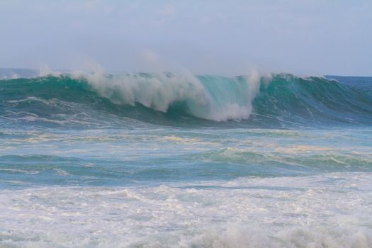 These huge waves with hollow barrels break off the north shore of Oahu in Hawaii during a big storm. These dangerous waves have major rip currents and a lot of power from the ocean but surfers are still lining up to surf.