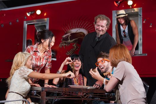 Happy group of people with pizza slices and chef at canteen