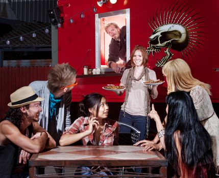 Caucasian woman bringing pizza orders to friends from canteen