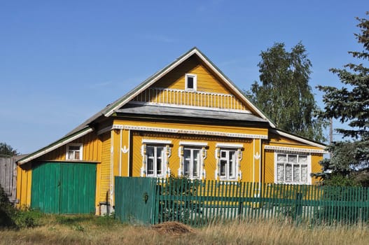 Beautiful wooden yellow country house with carved front, Russia