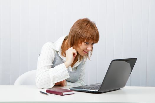Attractive smiling girl with a laptop in the office