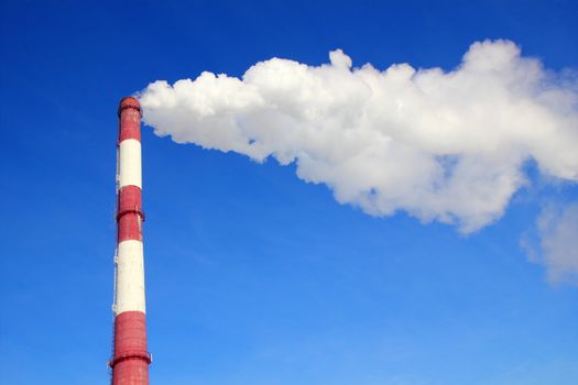 Smoking pipes of thermal power plant against blue sky
