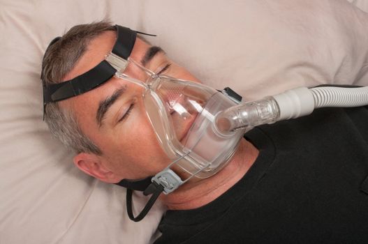 Man with sleep apnea and CPAP machine
