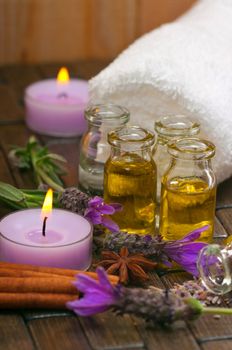 Spa concept with cotton towels, massage oil, aromatic lavender and candles