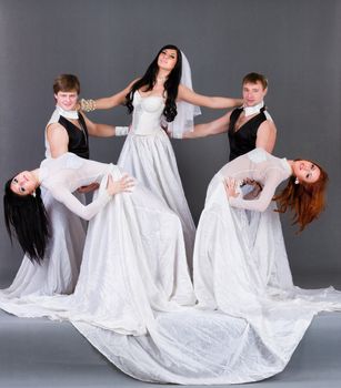 Actors in the wedding dress dancing. On a gray background in full length.