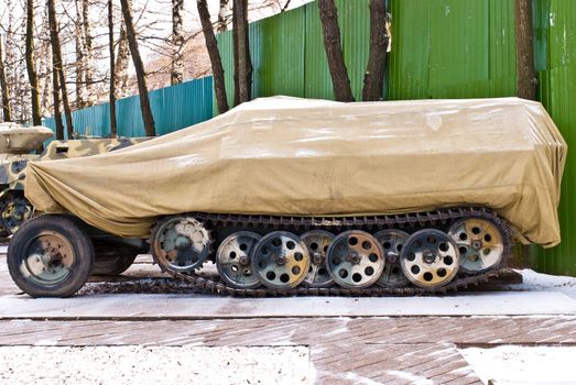 Old Russia military armored personnel carrier cover in brown cover. Taken in winter morning.