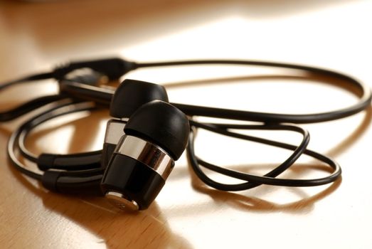 black unplugged ear buds on desk macro closeup