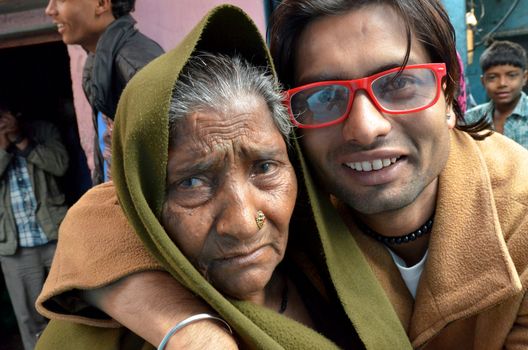 New Delhi,India-February 4, 2013:Portrait of a elderly woman and her  happy grandson in their poor neighborhood in New Delhi in February 4,2013.  50% of the population of New Delhi is thought to live in slums